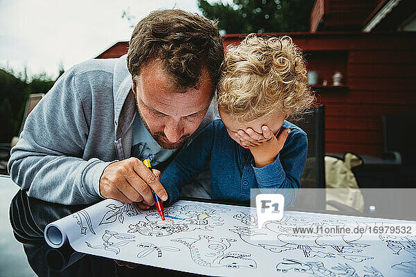 Vater und Kind malen während der Abriegelung gemeinsam draußen