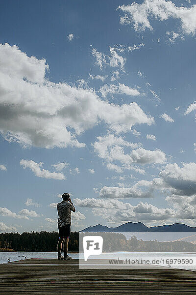 Mann mit Fahrradhelm steht auf einem Steg am Flagstaff Lake  Maine