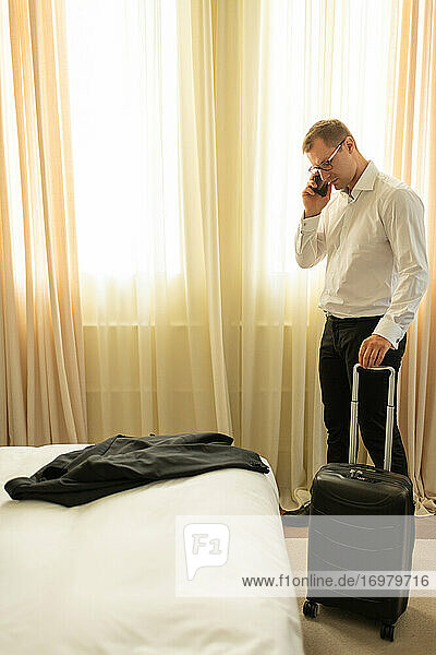 Erwachsener Geschäftsmann beim Telefonieren im Hotel