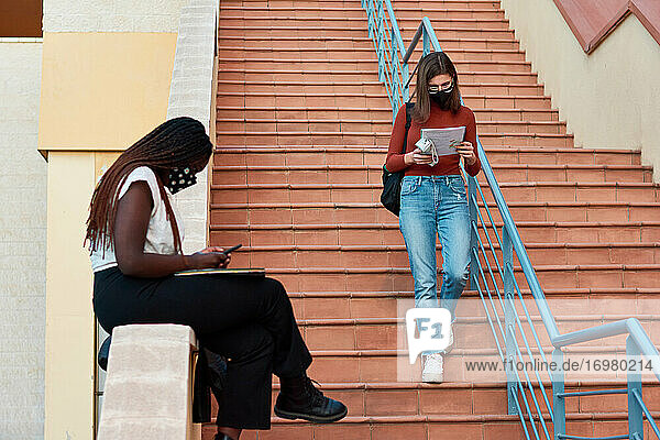 Zwei junge Studenten befinden sich auf einem Universitätscampus. Multiethnisches Konzept