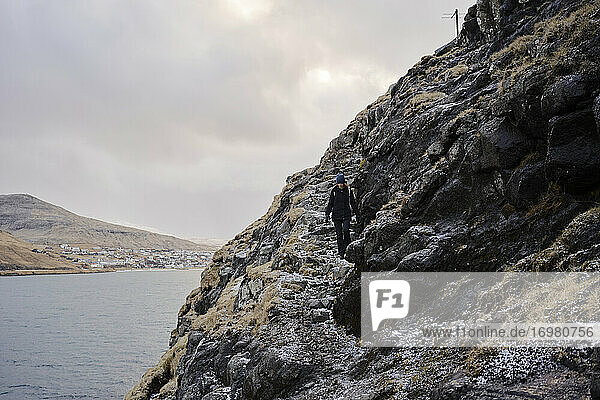 Wanderin auf den Färöer-Inseln entlang einer Klippe