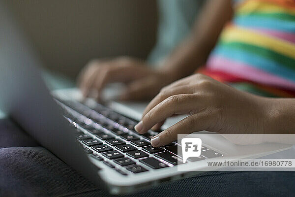 Nahaufnahme von bi-racial tween girl's Hände arbeiten auf Laptop
