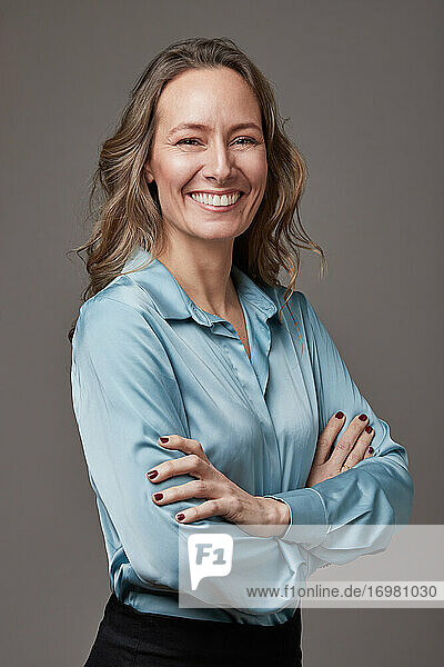 Retrato en estudio de mujer empresaria sobre fondo gris.