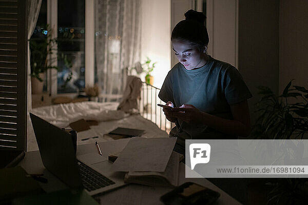 Schüler  die abends zu Hause ihr Smartphone benutzen