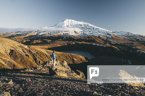 Young woman standing on top of a rock against Mt Ruapehu and Tama lake  Tongariro National Park