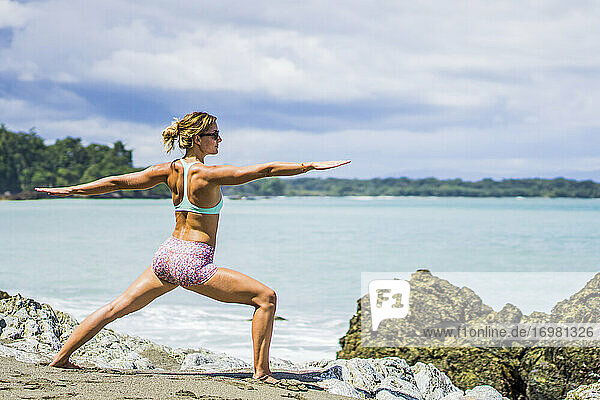 Female traveler doing yoga on beach