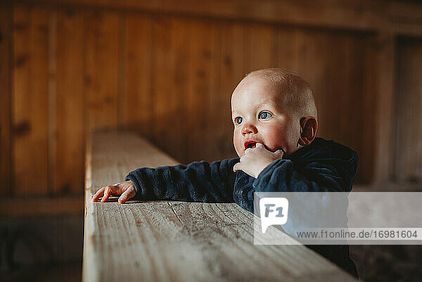 Baby Junge mit blauen Augen setzen Finger in den Mund Zahnen außerhalb