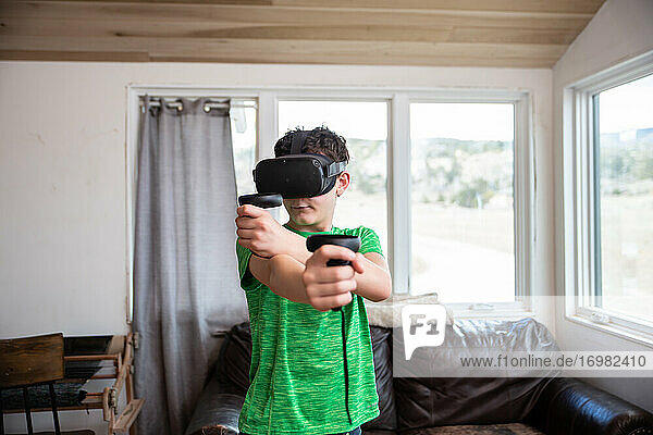 Teen boy playing with virtual reality headset on in living room