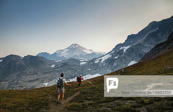 Zwei Wanderer klettern in der Morgendämmerung auf den Gipfel des Glacier Peak.
