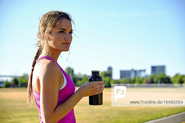 Female athlete taking a water break during workout