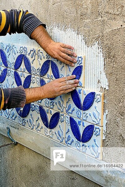 Ein Bauunternehmer  Fliesenleger  der Azulejos an einer Außenwand anbringt  Algarve  Portugal  Europa