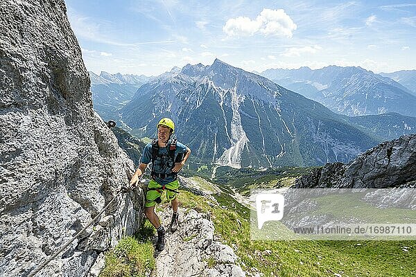 Bergsteiger an einem gesicherten Klettersteig  Mittenwalder Höhenweg  Ausblick auf Bergpanorama  Karwendelgebirge  Mittenwald  Bayern  Deutschland  Europa