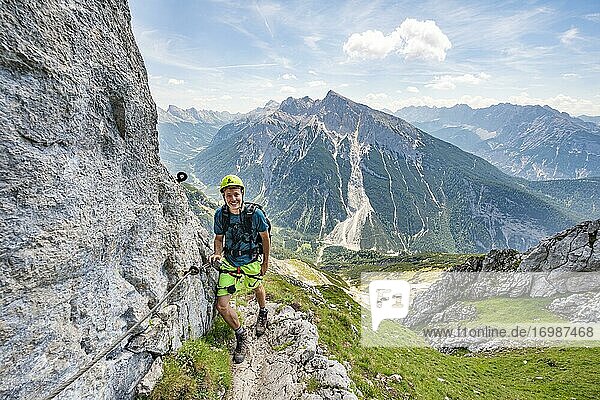 Mountaineer on a secured via ferrata  Mittenwalder Höhenweg  view of mountain panorama  Karwendel Mountains  Mittenwald  Bavaria  Germany  Europe