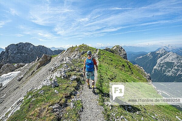 Bergsteiger wandert auf einem Grat  Klettersteig Mittenwalder Höhenweg  Karwendelgebirge  Mittenwald  Bayern  Deutschland  Europa