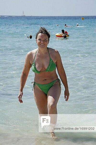 Frau beim Baden im Mittelmeer. Strandleben am Playa Son Xoriguer in Cala'n Bosch auf Menorca. Spanien.