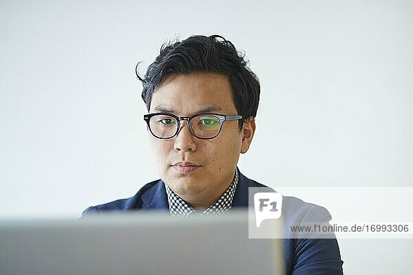 Young Japanese businessman working with laptop
