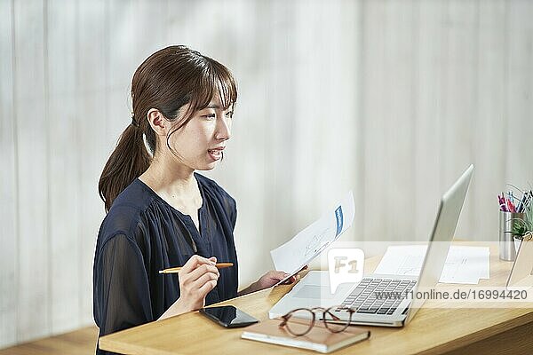 Young Japanese businesswoman having remote meeting at home