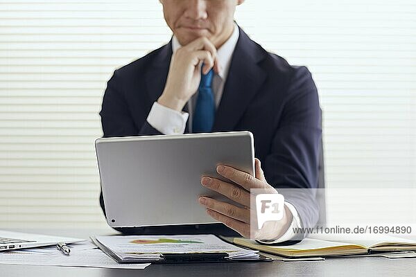 Young Japanese businessman working with tablet