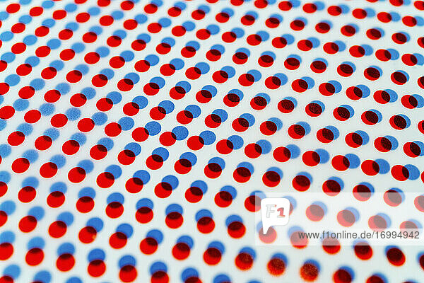 3D rote und blaue Punkte Muster überlappend auf weißem Hintergrund