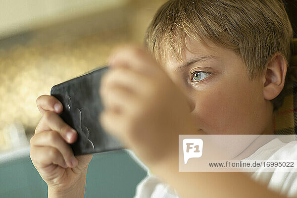 Close up fokussiert Junge spielt Videospiel auf Smartphone