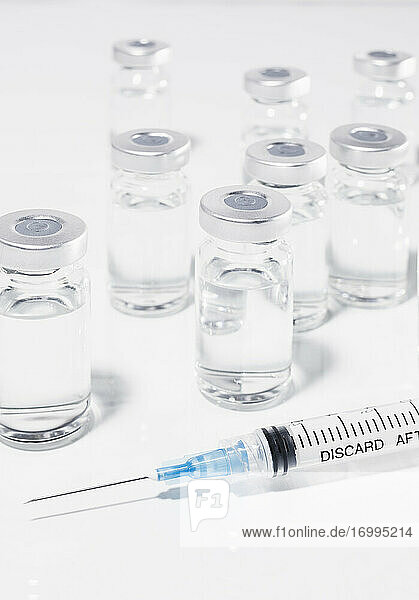 COVID-19-Impfstoff-Ampullen und Spritze auf weißem Hintergrund