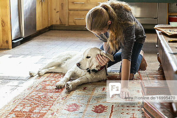 Teenage girl caressing her English Cream Golden Retriever dog