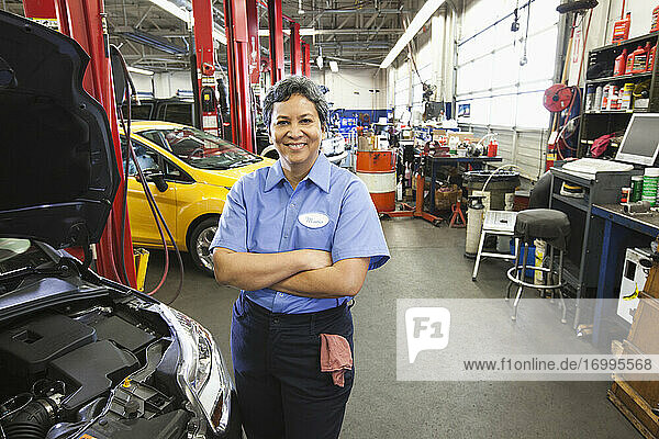 Portrait of female hispanic mechanic in auto repair shop