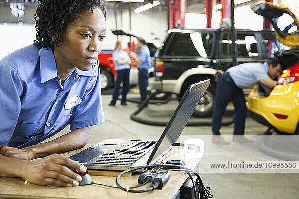 Mechanikerin mit Laptop  Diagnoseelektronik  in einer Autowerkstatt