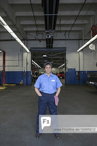 Portrait of female hispanic mechanic in auto repair shop