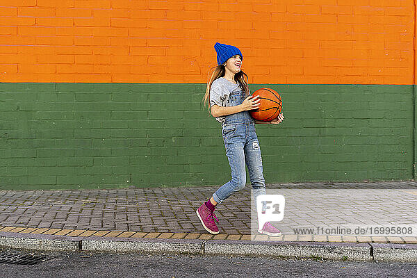 Young girl playing basketball  laughing
