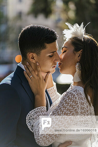 Wedding couple kissing on sunny day