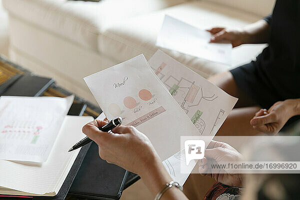 Professionelle Designerin  die einem Kunden ihr Projekt zeigt  während sie zu Hause im Büro sitzt