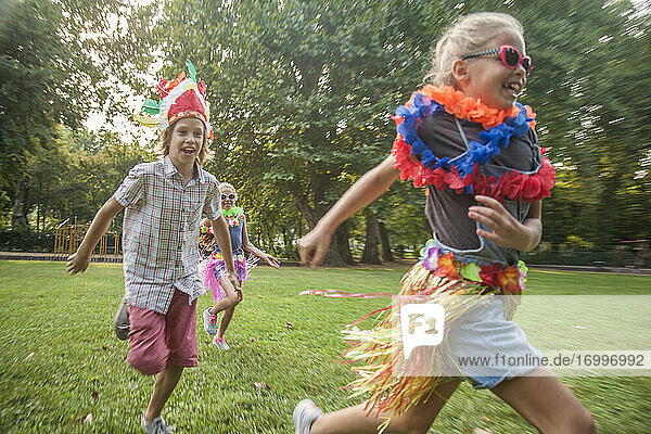 Cheerful children in costume running at park