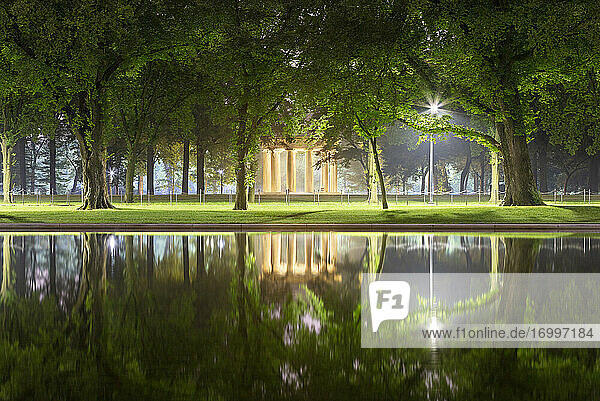 USA  Washington DC  Trees reflecting in Lincoln Memorial Reflecting Pool at night with District of Columbia War Memorial in background