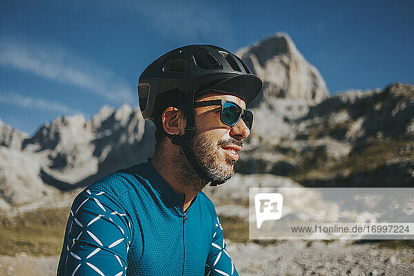 Radfahrer mit Sonnenbrille und Fahrradhelm im Nationalpark Picos de Europa an einem sonnigen Tag  Kantabrien  Spanien