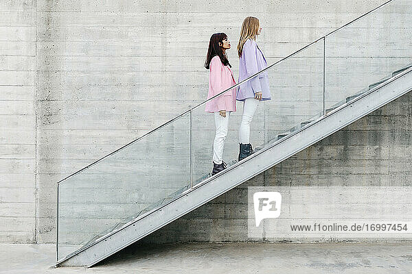 Junge Schwestern stehen auf den Stufen an der Mauer