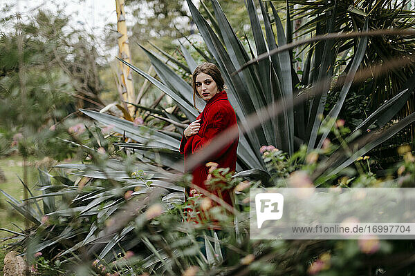 Frau mit rotem Mantel in einem Park