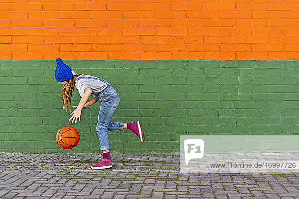 Junges Mädchen spielt Basketball  dribbelt