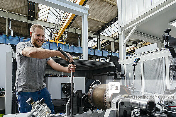 Handwerker lächelnd bei der Arbeit in einer Fabrik