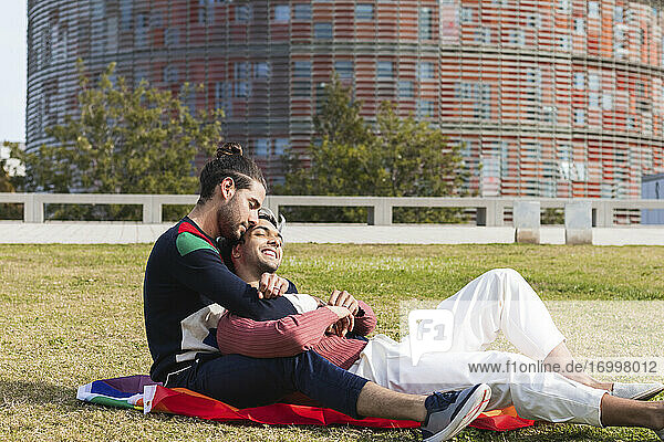 Affectionate man embracing partner while sitting in park