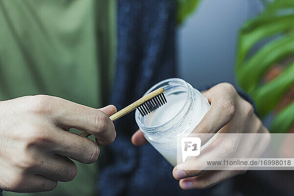 Mann mit Bambuszahnbürste und Zero Waste Zahnpasta