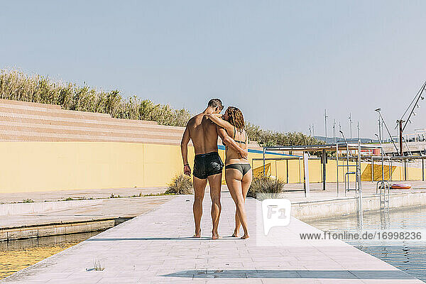 Young couple walking on a pier at the sea