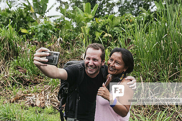 Fröhlicher männlicher Tourist macht ein Selfie mit einer Frau in Misahualli  Ecuador