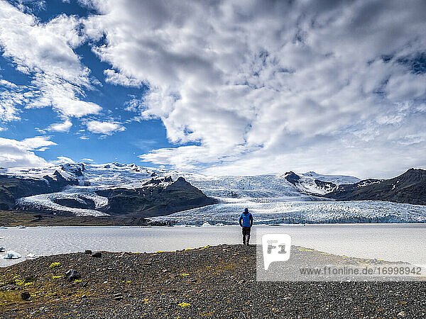 Mann betrachtet die Aussicht vom Berg gegen den bewölkten Himmel am Breidamerkurjokull  Island