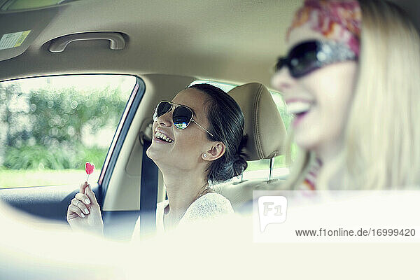 Lachende Freundinnen  die sich während einer Autoreise im Auto vergnügen