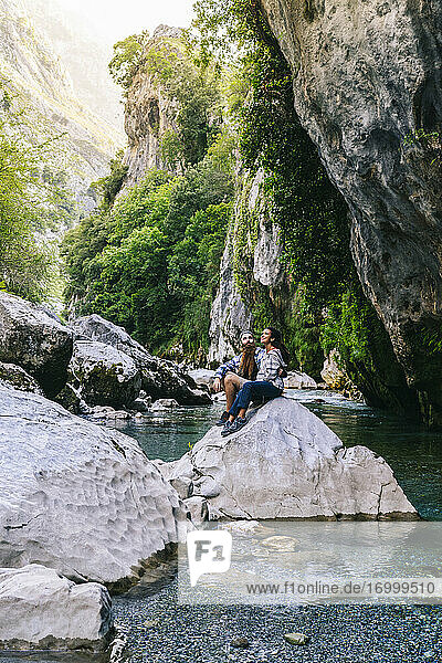 Junges Paar auf einem Felsen sitzend beim Wandern im Gebirge Picos De Europa  Asturien  Spanien