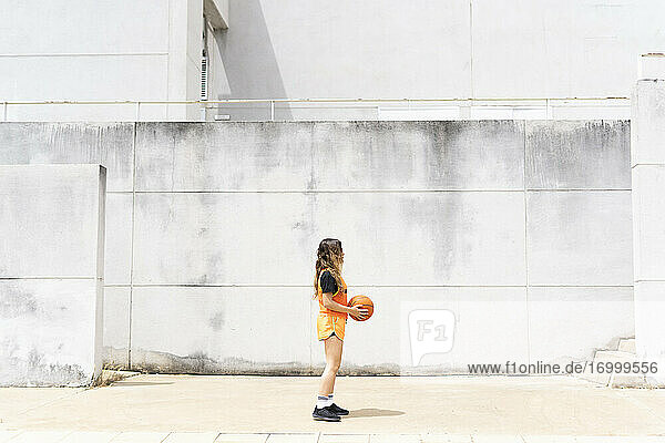 Teenager-Mädchen mit Basketball stehend im Freien