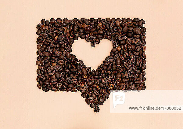 Geröstete Kaffeebohnen in Form eines Herzens in einer Online-Chatblase angeordnet