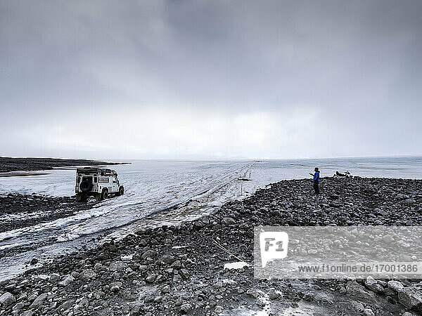 Mann mit Geländewagen am Gletscher im Urlaub  Langjokull  Island