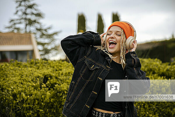 Cheerful blond woman enjoying music through headphones